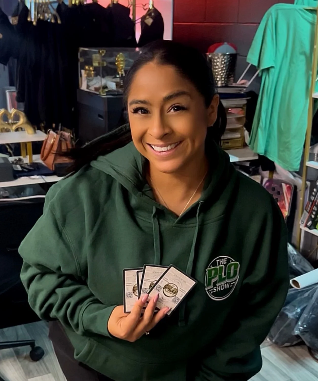 PLO Show fan in the green hoodie holding poker cards